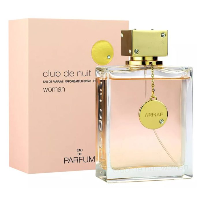 Club De Nuit Eau de Parfum 200 ml para Mujer por ARMAF. La imagen muestra el frasco del perfume y su caja. El frasco tiene forma rectangular con diseño transparente, líquido rosa claro en el interior y tapón cuadrado dorado con cadena y colgante dorados. La caja es de color rosa suave con el texto "club de nuit" y "ARMAF" en letras negras.