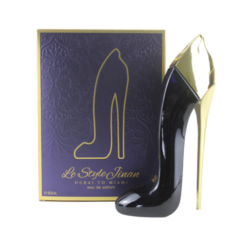 Le Style Jinan Dubai to Miami Eau de Parfum 80ml frasco y envase de Zoghbi. El frasco del perfume tiene forma de zapato de tacón alto, principalmente negro con detalles dorados. El envase es morado con la silueta de un zapato de tacón dorado.
