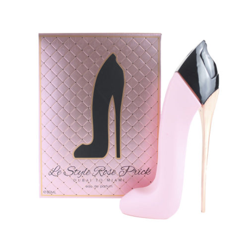 Vista frontal del envase del perfume "Le Style Rose Prick", con un fondo rosa acolchado con la silueta negra de un tacón alto y el texto "Dubai to Miami, eau de parfum", junto a un frasco de perfume rosa a juego con forma de tacón alto.