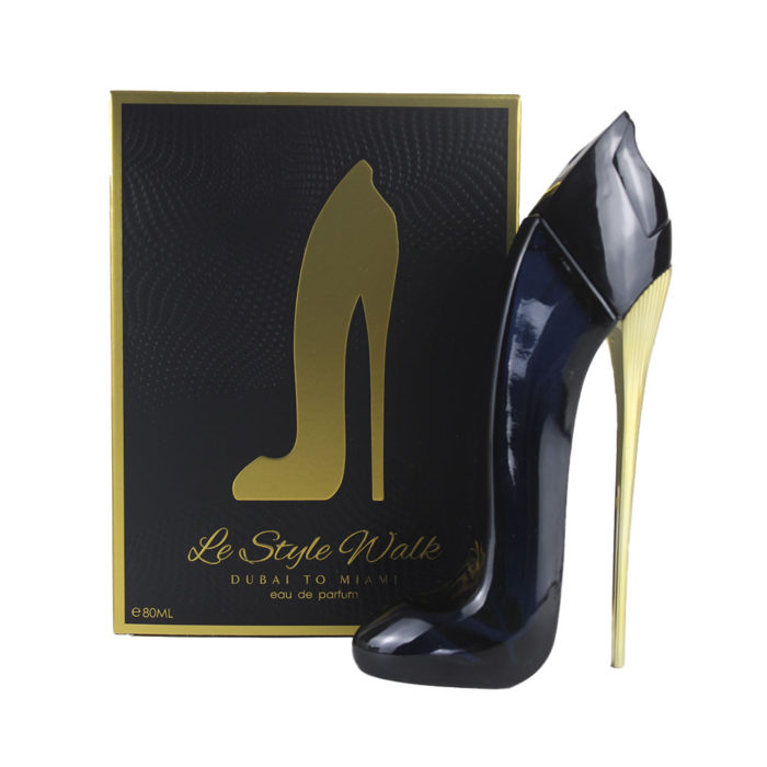 Imagen del estuche del perfume "Le Style Walk", que incluye una caja oscura y un frasco azul marino con forma de tacón alto y tacón dorado, expuestos uno junto al otro.