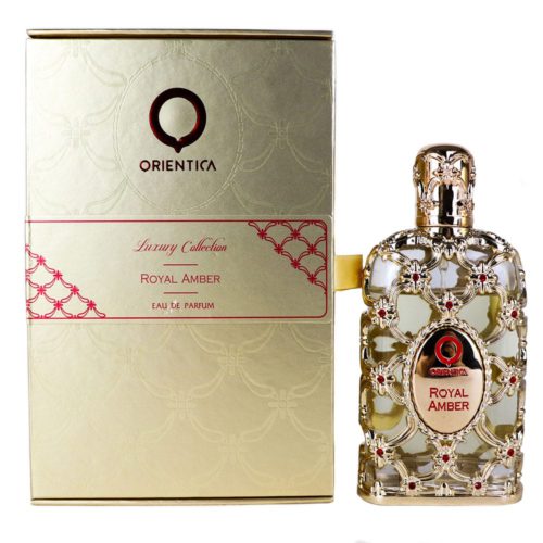 Eau de Parfum Orientica Royal Amber, 2.7 fl oz (80 ml). La botella de perfume está decorada con un lujoso diseño de celosía dorada con detalles de piedras rojas y una tapa dorada ornamentada. El empaque es dorado con patrones en relieve y detalles en rojo.