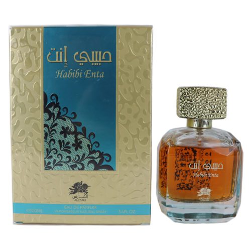Frasco de perfume Habibi Enta con líquido ámbar, tapa dorada texturizada y texto árabe dorado, junto a su empaque beige y turquesa con patrones ornamentados.
