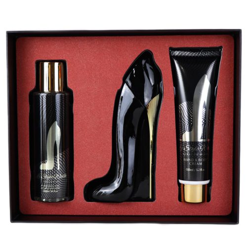 Un set de regalo que incluye un frasco de perfume en forma de tacón alto, una crema para manos y cuerpo, y un spray perfumado, presentado sobre un fondo rojo.
