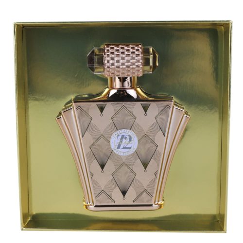 Un primer plano del frasco de perfume Z12 en rosa pastel, decorado con un emblema plateado y un patrón floral en relieve, con un lazo plateado.