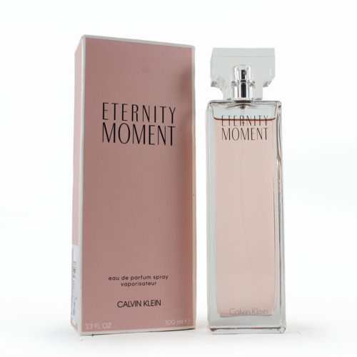 Eau de Parfum Calvin Klein Eternity Moment para mujer, 3.3 fl oz (100 ml). La botella de perfume es alta y rectangular con líquido rosado en su interior y una tapa transparente. El empaque es una caja rosa con texto minimalista en negro.