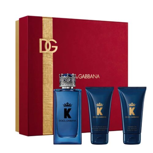 Set de fragancia K by Dolce & Gabbana para hombre, con un frasco azul de Eau de Parfum de 100 ml con tapa en forma de corona, bálsamo para después del afeitado y gel de ducha, sobre un empaque rojo y dorado.