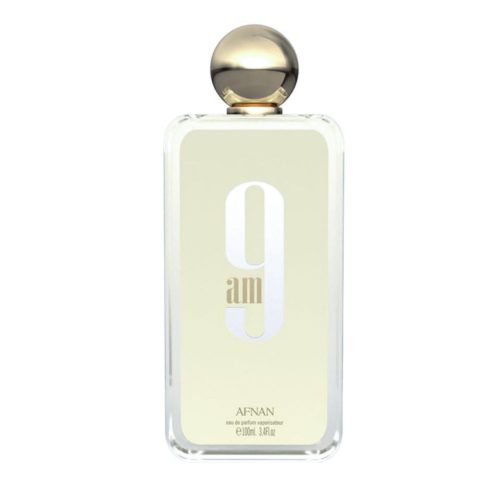 Primer plano de un frasco de perfume transparente de "9AM Eau de Parfum" de Afnan, con un tapón esférico dorado y una etiqueta minimalista en beige.